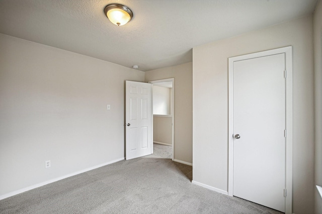 unfurnished bedroom with a textured ceiling and light carpet