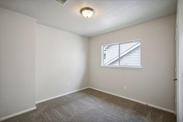 unfurnished room with dark colored carpet and a textured ceiling