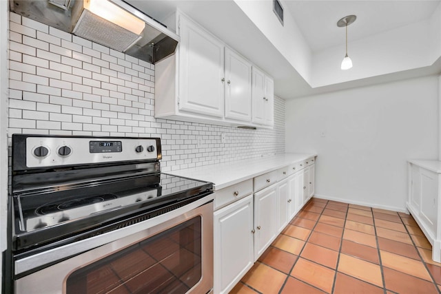 kitchen featuring backsplash, wall chimney range hood, electric stove, decorative light fixtures, and white cabinets