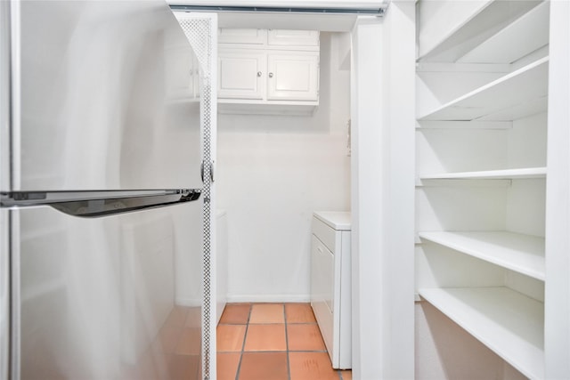 walk in closet featuring independent washer and dryer and light tile patterned floors