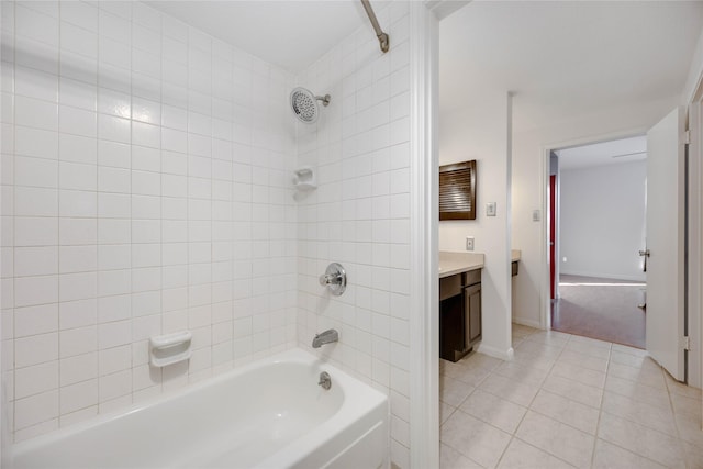 bathroom featuring tile patterned flooring, vanity, and tiled shower / bath