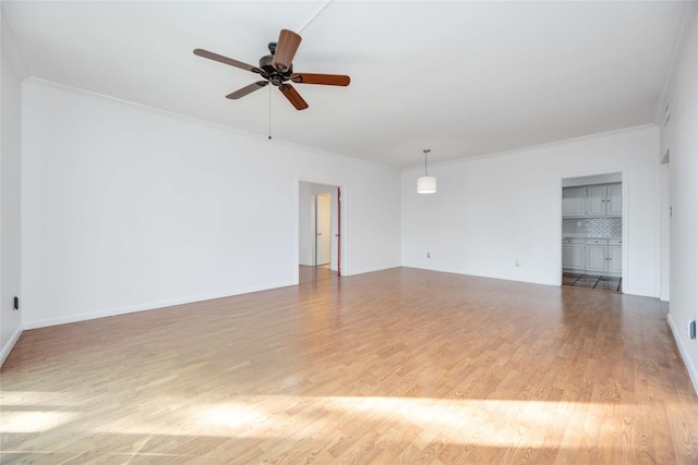 empty room with ceiling fan, ornamental molding, and light hardwood / wood-style flooring