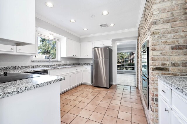 kitchen featuring sink, ornamental molding, appliances with stainless steel finishes, white cabinetry, and brick wall