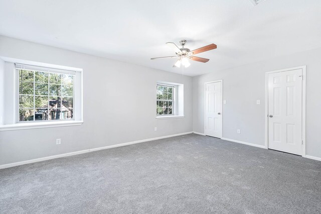 carpeted spare room with ceiling fan