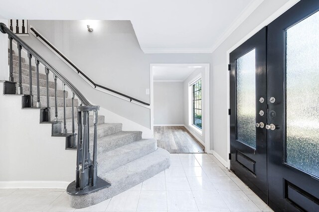 entryway featuring french doors, light hardwood / wood-style floors, and crown molding