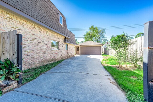 view of property exterior with an outdoor structure and a garage