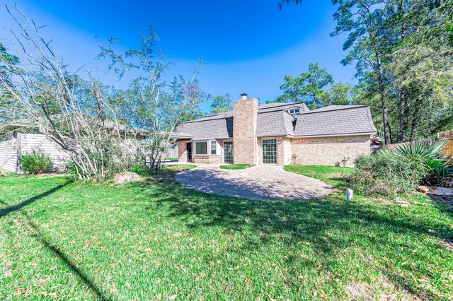 rear view of property featuring a yard and a patio area