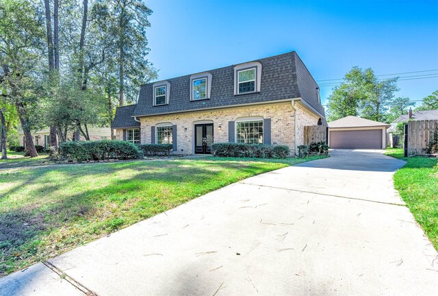 view of front of home with a front yard, an outbuilding, and a garage