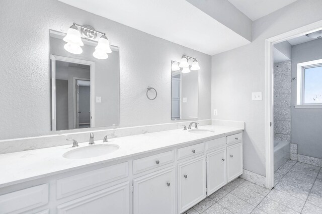 bathroom featuring vanity, tile patterned floors, and tiled shower / bath combo