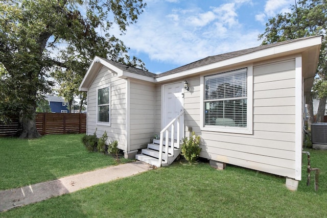 view of front facade featuring a front yard and central air condition unit