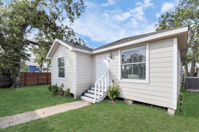 view of front of home featuring central AC and a front lawn