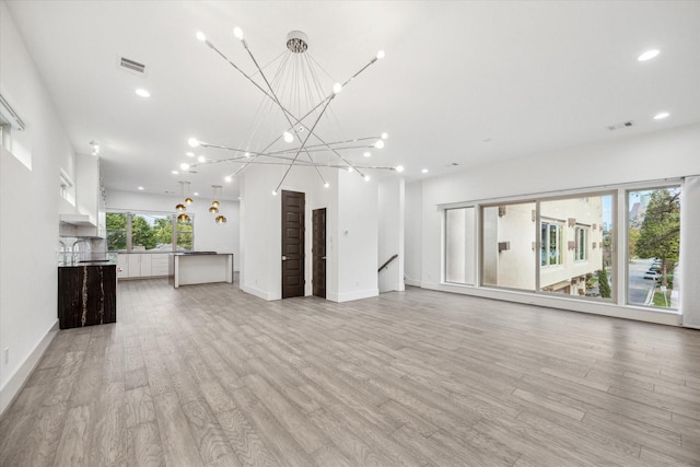 unfurnished living room with sink and light wood-type flooring