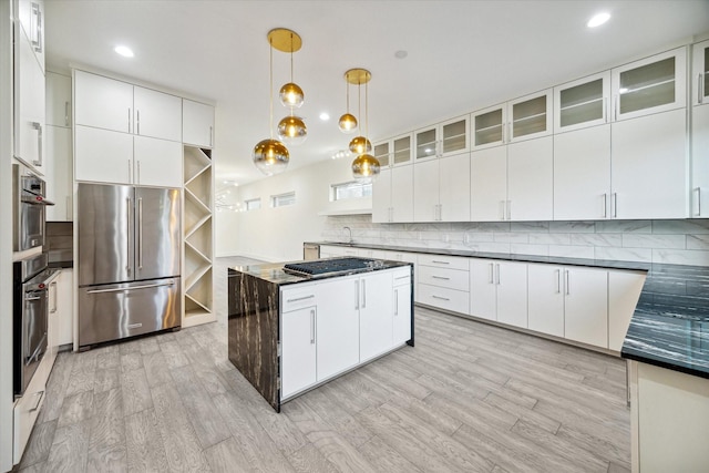 kitchen featuring white cabinets, appliances with stainless steel finishes, light hardwood / wood-style flooring, and pendant lighting