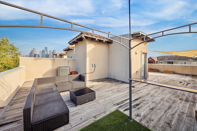 wooden terrace with an outdoor hangout area and central air condition unit