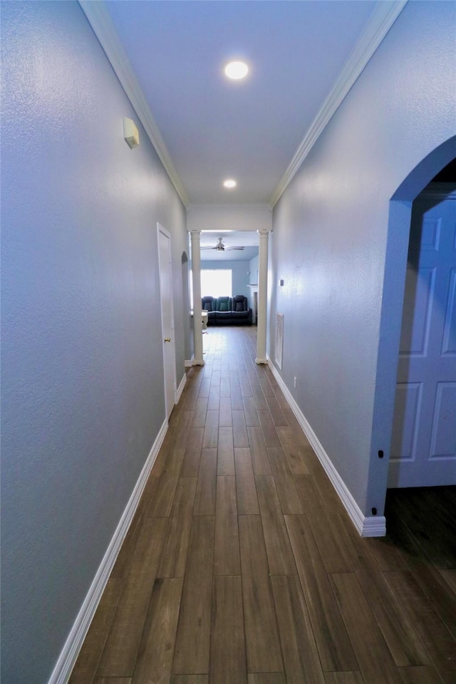 hallway featuring ornamental molding, dark wood-type flooring, and decorative columns