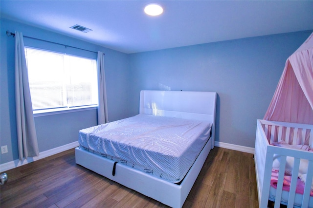 bedroom with dark hardwood / wood-style floors