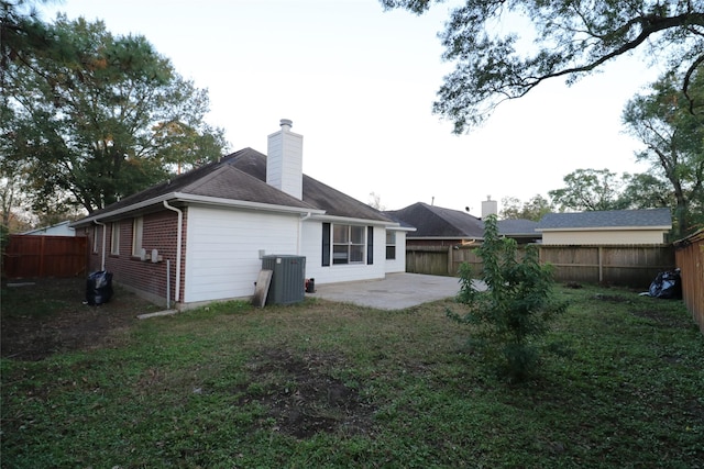 rear view of property featuring a lawn, a patio, and central AC