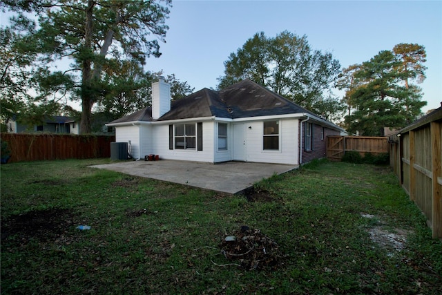 rear view of house with a lawn, a patio, and central AC