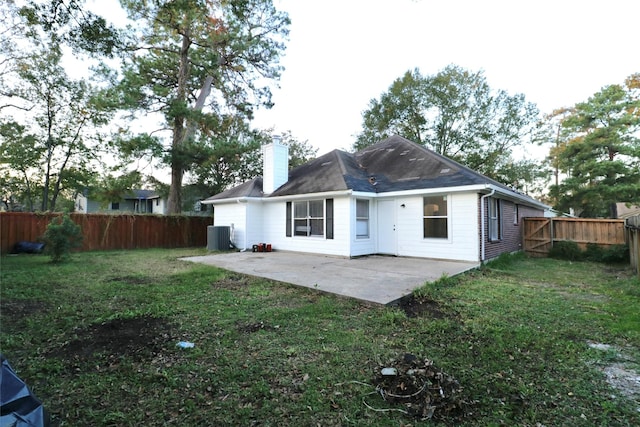 rear view of house with a lawn, a patio area, and central AC