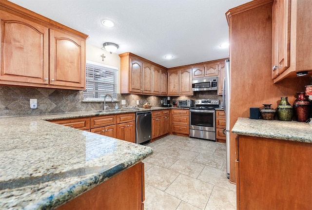 kitchen featuring sink, light stone countertops, stainless steel appliances, and tasteful backsplash