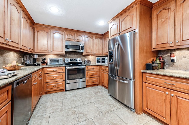 kitchen featuring light stone countertops, stainless steel appliances, light tile patterned floors, and tasteful backsplash