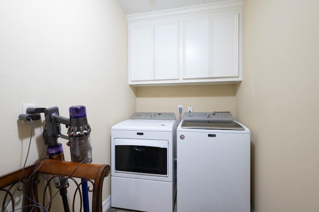 laundry area with washer and dryer and cabinets