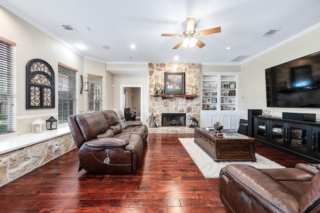 living room featuring a fireplace, built in shelves, crown molding, and dark wood-type flooring