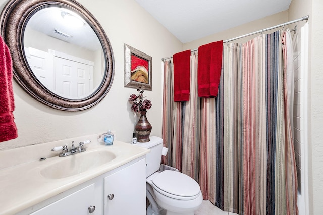 bathroom with vanity, toilet, a textured ceiling, and walk in shower