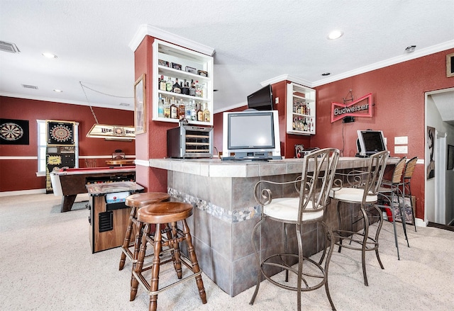 bar featuring ornamental molding and a textured ceiling