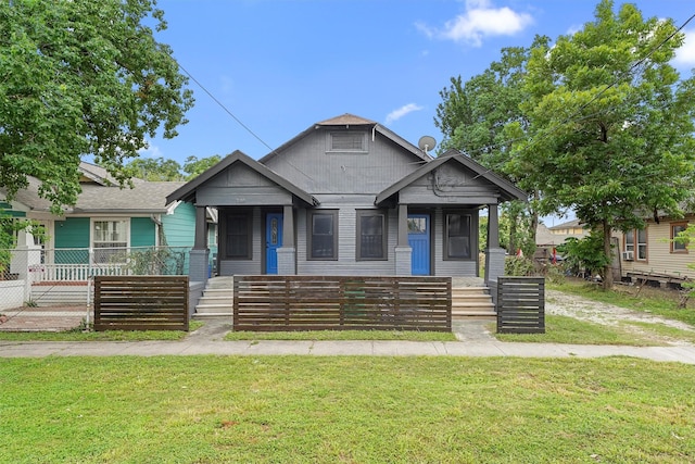 bungalow-style house featuring covered porch and a front yard