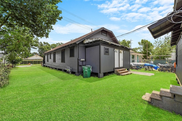 rear view of house featuring a lawn