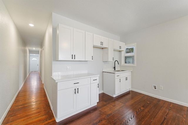 kitchen featuring dark hardwood / wood-style floors, white cabinetry, and sink