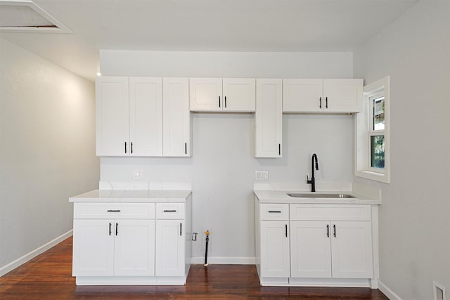 kitchen with dark hardwood / wood-style floors, white cabinetry, and sink