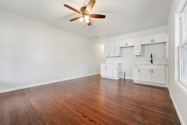 unfurnished living room with dark hardwood / wood-style flooring, ceiling fan, and sink