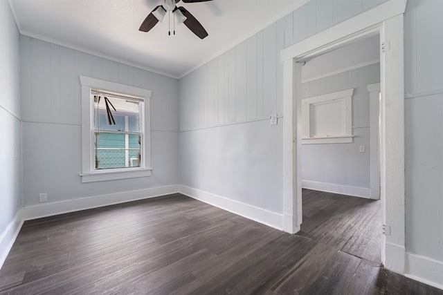 unfurnished room with wooden walls, dark hardwood / wood-style floors, ceiling fan, and crown molding