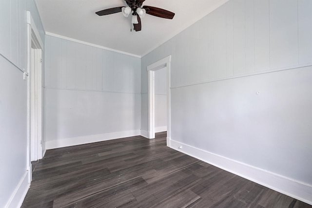 spare room featuring dark hardwood / wood-style flooring, ceiling fan, and wood walls