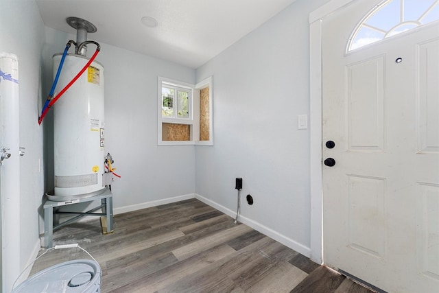 laundry room featuring gas water heater and dark hardwood / wood-style floors