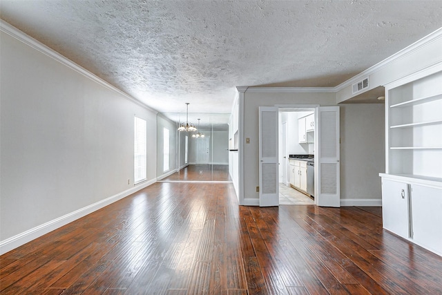 unfurnished living room with dark hardwood / wood-style floors, crown molding, a textured ceiling, and a chandelier