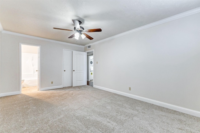 unfurnished bedroom featuring light carpet, ensuite bath, ceiling fan, and crown molding