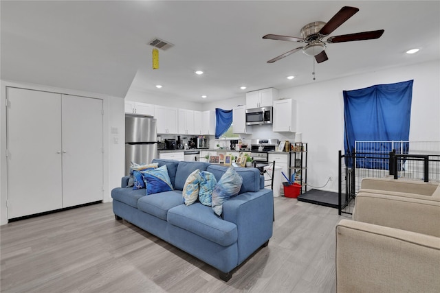 living room with light wood-type flooring and ceiling fan