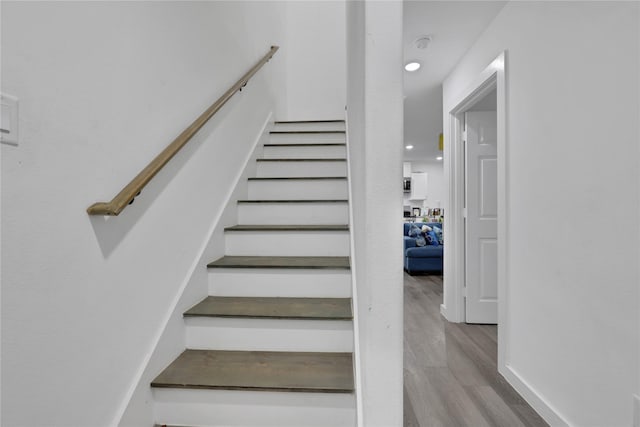 staircase with hardwood / wood-style floors