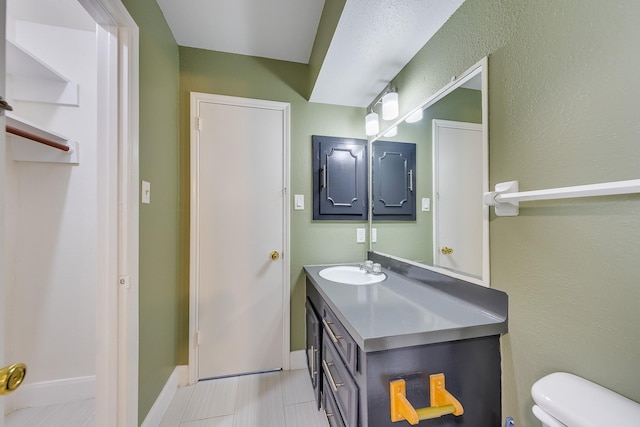 bathroom with tile patterned flooring, vanity, and toilet