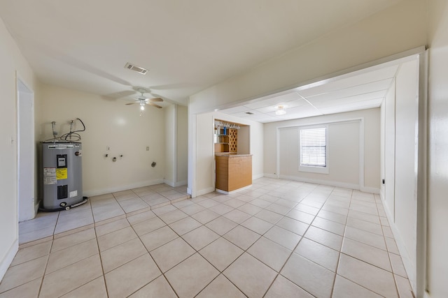 unfurnished living room featuring light tile patterned flooring, ceiling fan, and water heater