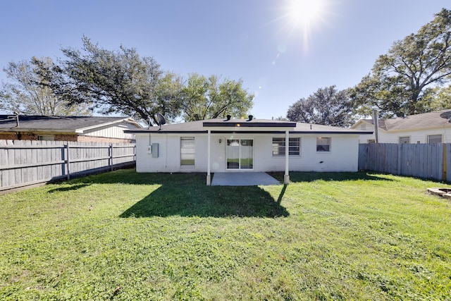 back of house with a yard and a patio