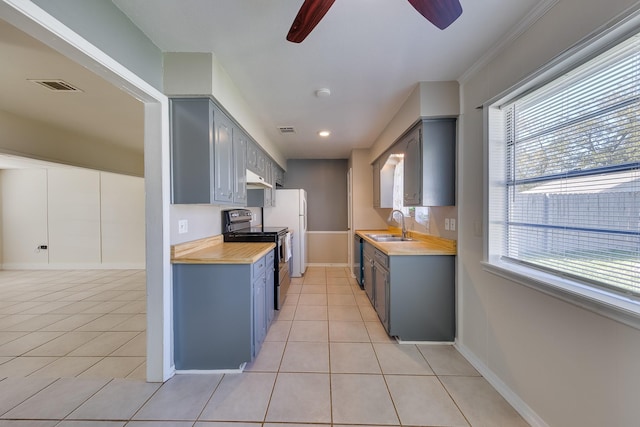 kitchen with butcher block countertops, plenty of natural light, light tile patterned flooring, and stainless steel appliances