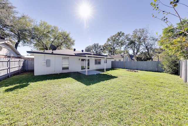 rear view of property featuring a lawn and a patio