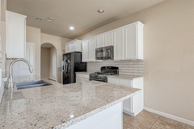 kitchen with white cabinetry, sink, tasteful backsplash, light tile patterned flooring, and black appliances