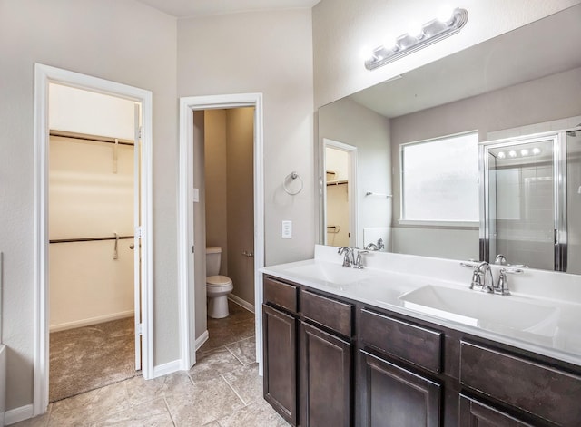 bathroom featuring vanity, toilet, and an enclosed shower