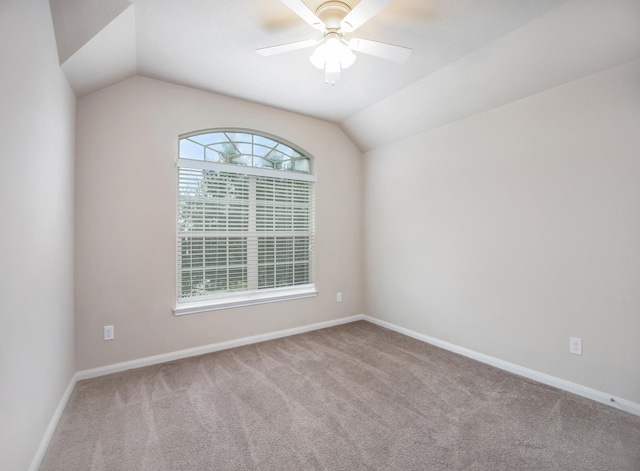 carpeted empty room with vaulted ceiling and ceiling fan