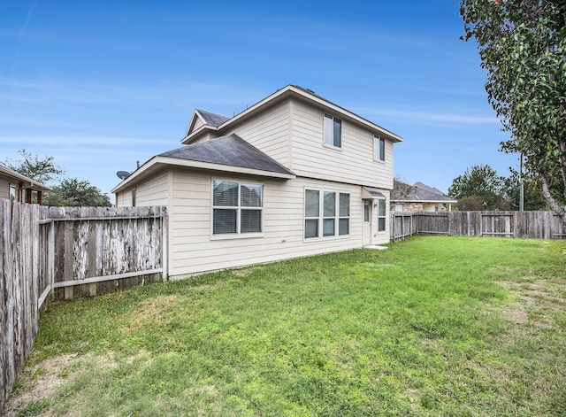 rear view of property featuring a lawn